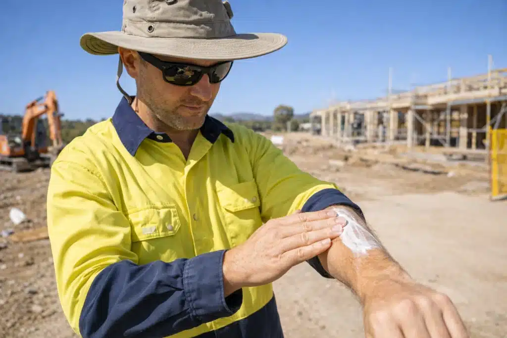Outdoor worker in Canberra using protective clothing and sunscreen to prevent skin cancer